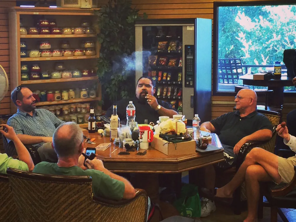 Members around a table at a club meeting, pipes lit
