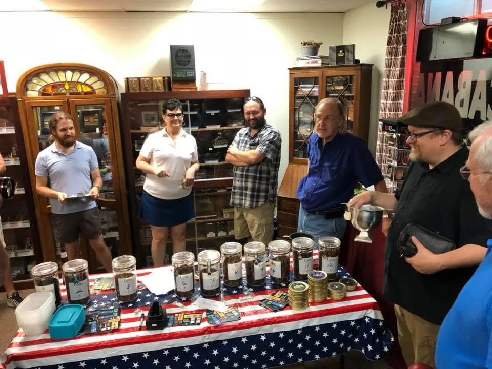 Members gathered at a tobacco tasting table
